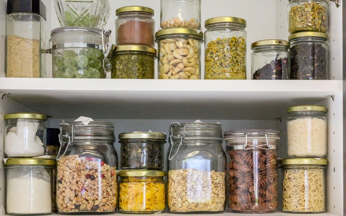 Organized pantry shelves with jars of dry goods