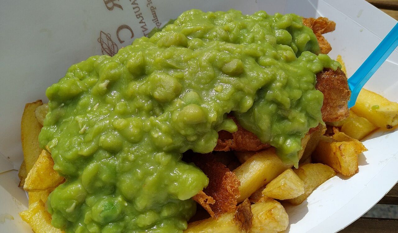 Vegan fish and chips topped with mushy peas