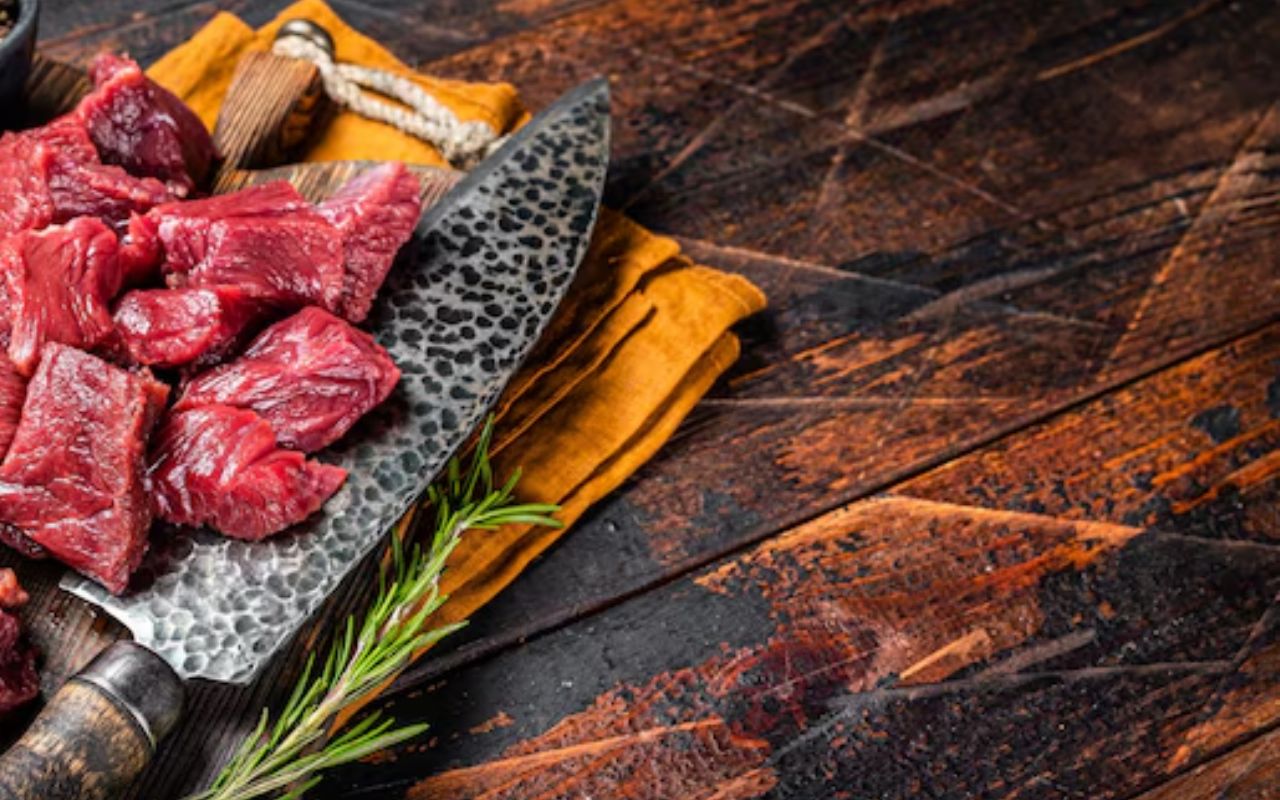 Raw venison cubes on a cleaver