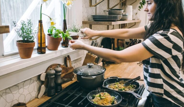 Woman standing in kitchen cooking