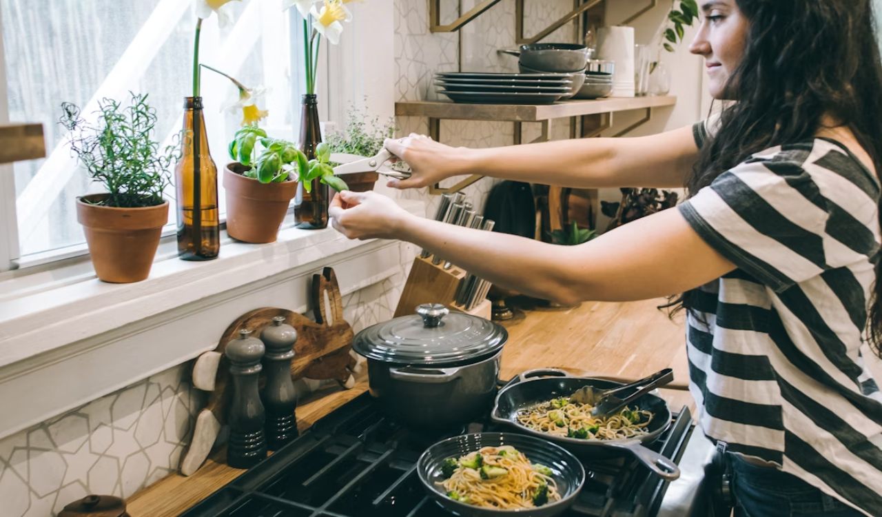 Woman standing in kitchen cooking