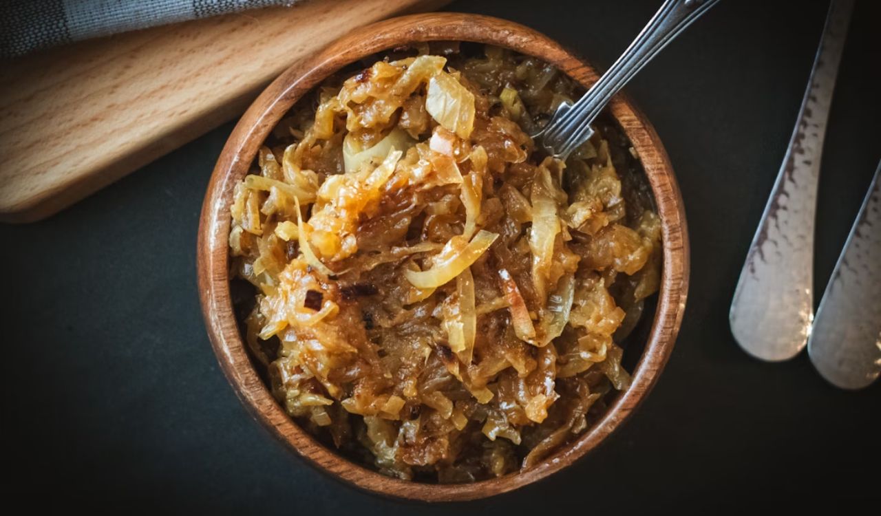 a small wooden bowl overflows with rich caramelized onion