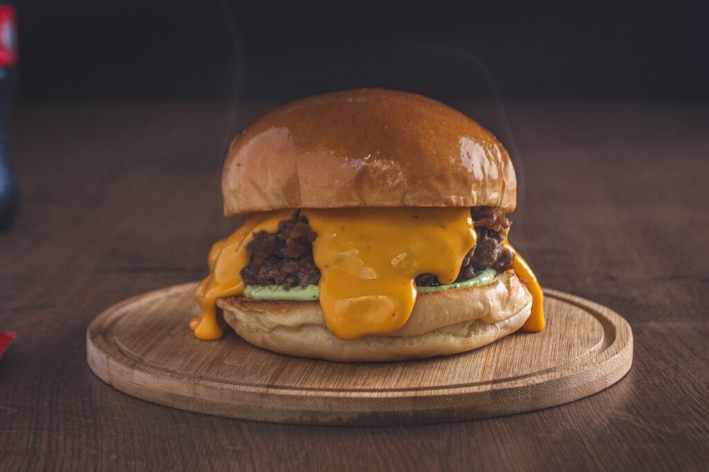 Juicy burger with melted cheese and condiments, shot close up.