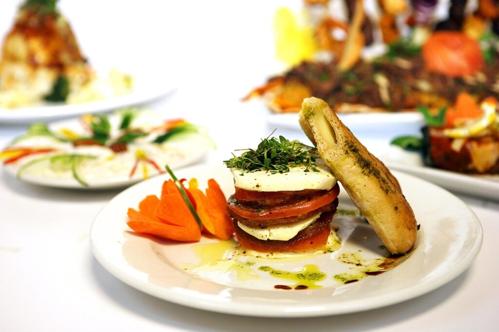 Alternating slices of ripe tomatoes and mozzarella with basil leaves, drizzled in olive oil.