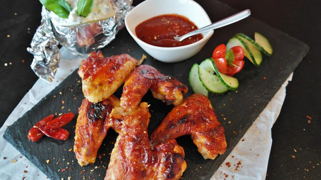 Buffalo chicken sliders on a wooden serving board.