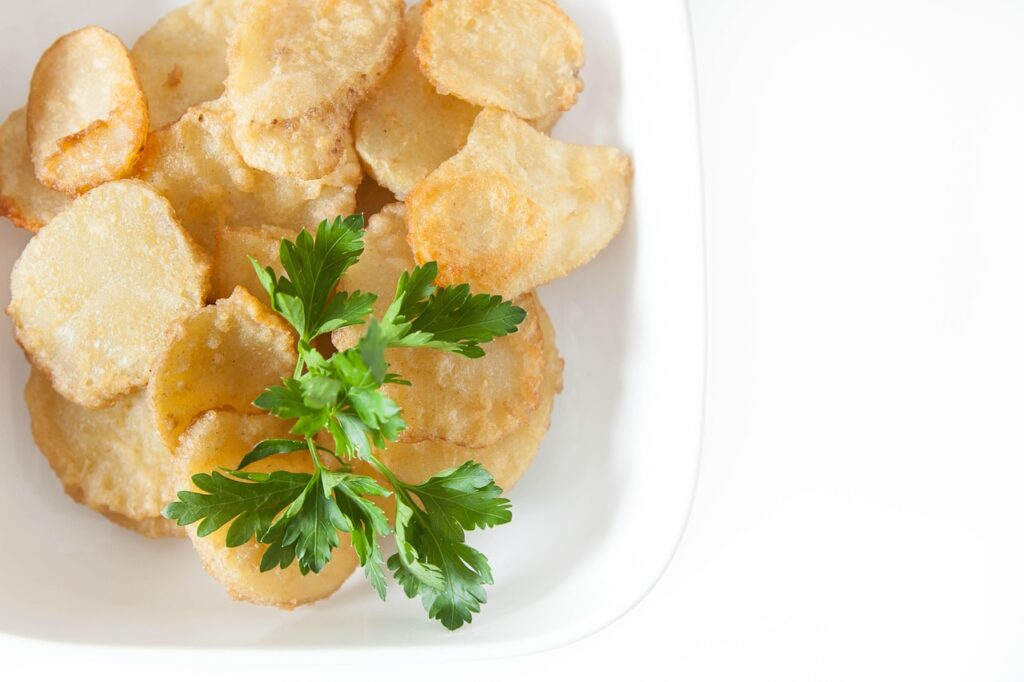 A close-up of golden potato chips piled high in a bowl.