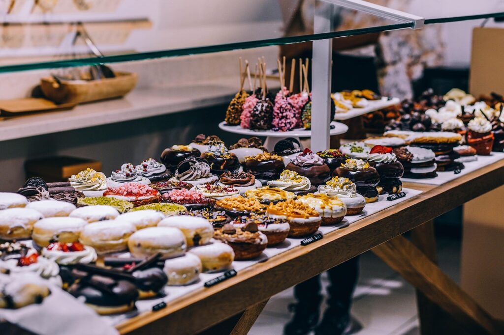 Assorted glazed and frosted doughnuts on a rack.