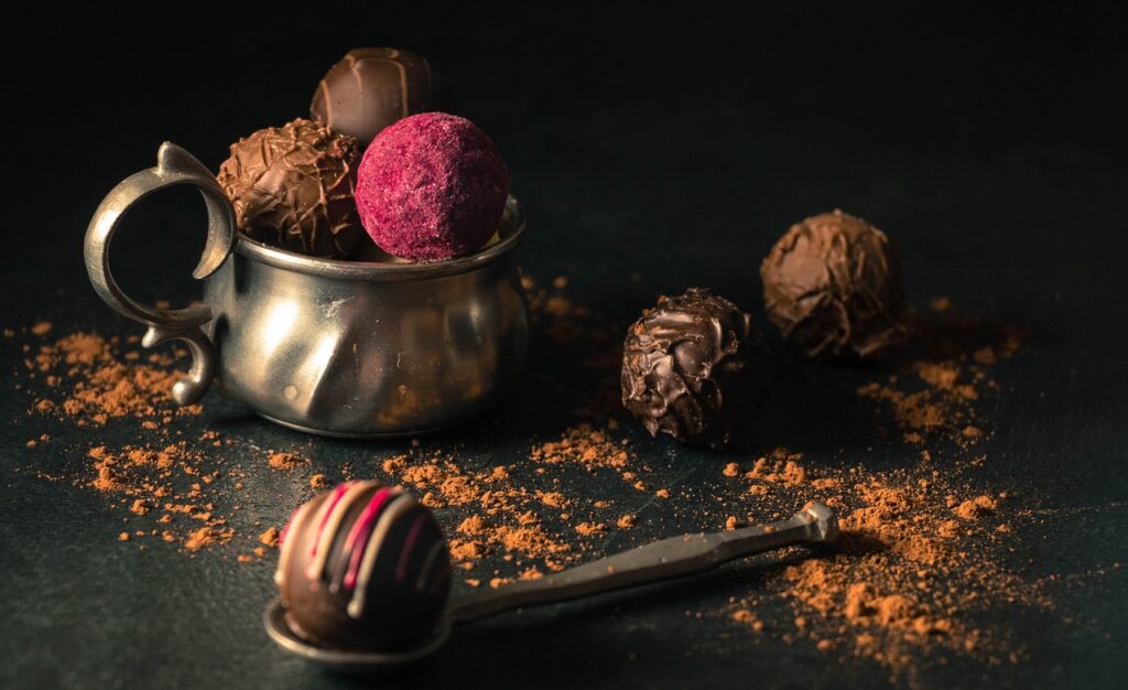 Nutella and chocolate truffles dusted with cocoa powder in a small bowl.