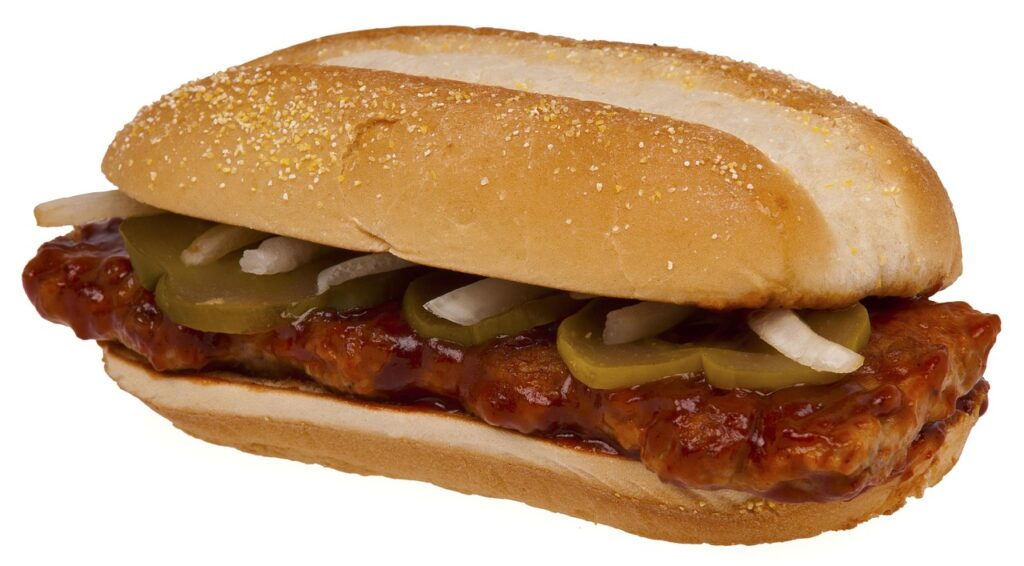 Sloppy Joes piled on buns with pickles.