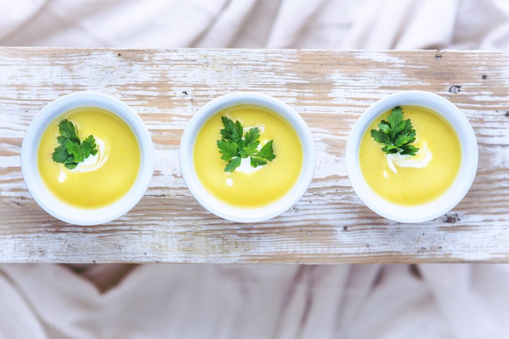 Garnished potato leek soup in a bowl with chives sprinkled on top.