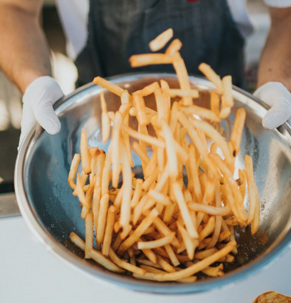 person tossing fries