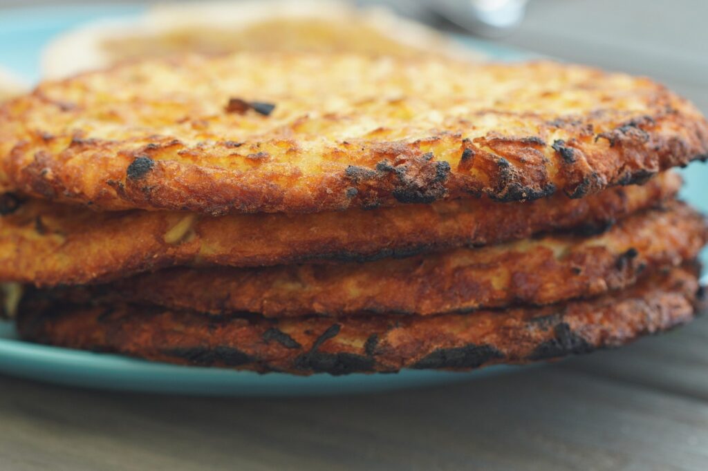 Cornmeal griddle cakes stacked on a plate.