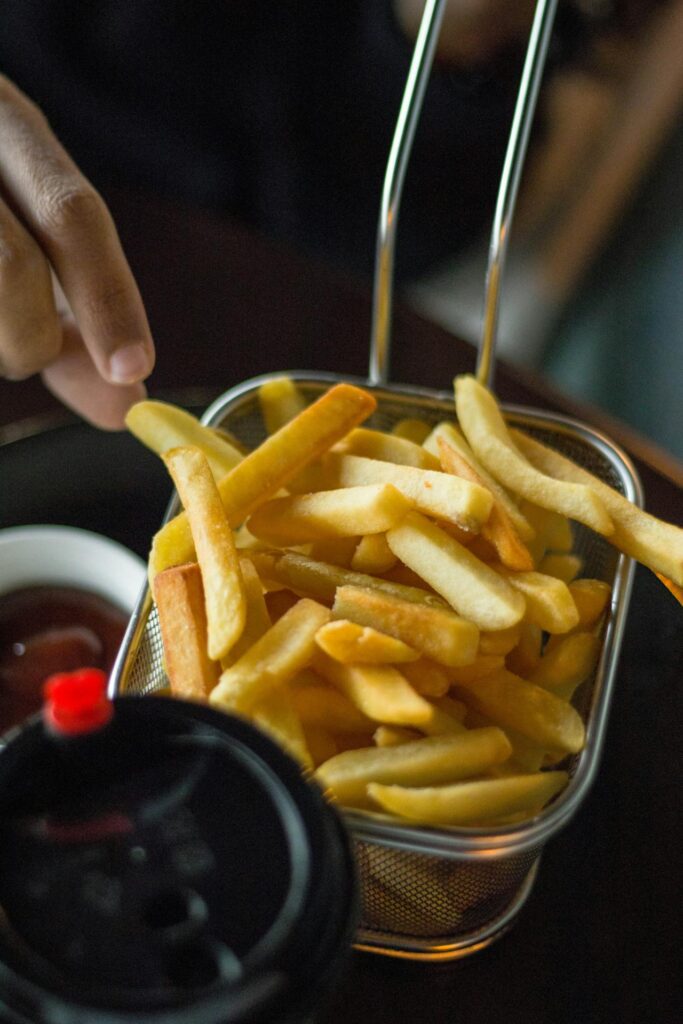 Close-up of crispy fries in an air fryer basket.