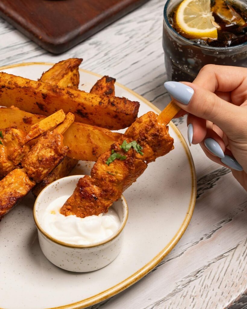 Grilled peanut butter chicken skewers with dipping sauce.