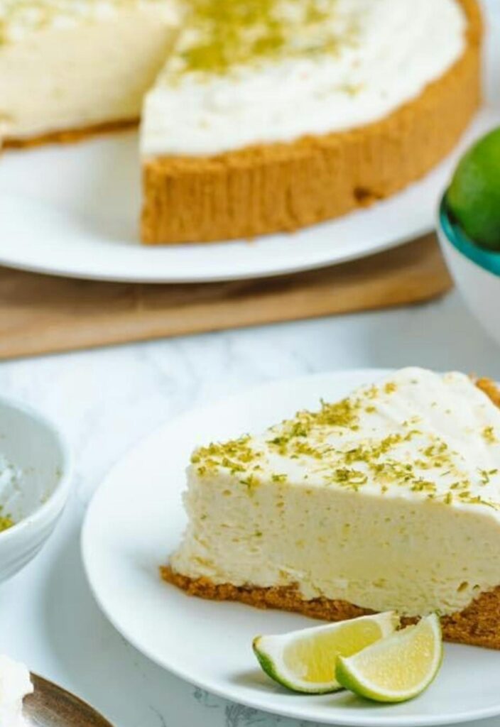 A key lime pie slice with whipped cream and lime zest.
