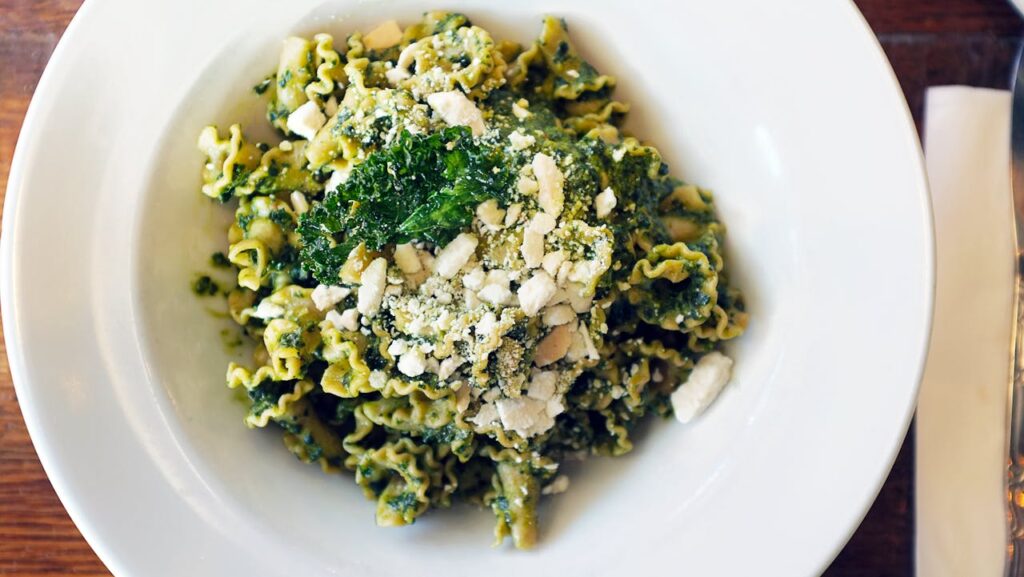 Pesto alla Genovese: Mortar and pestle with fresh basil and pine nuts.