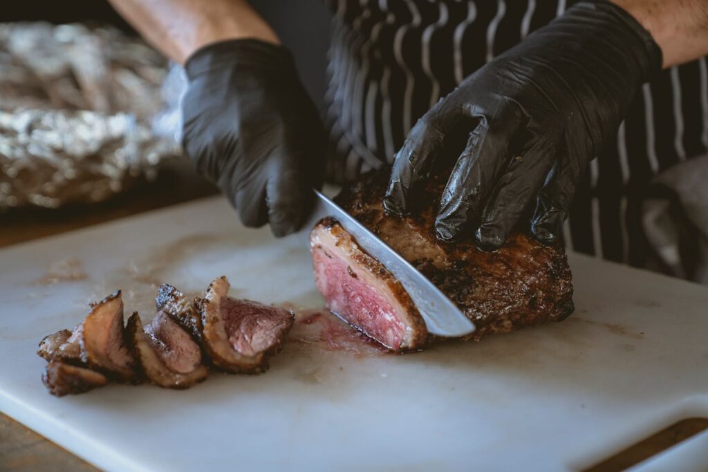Close-Up Shot of a Person Slicing Cooked Meat