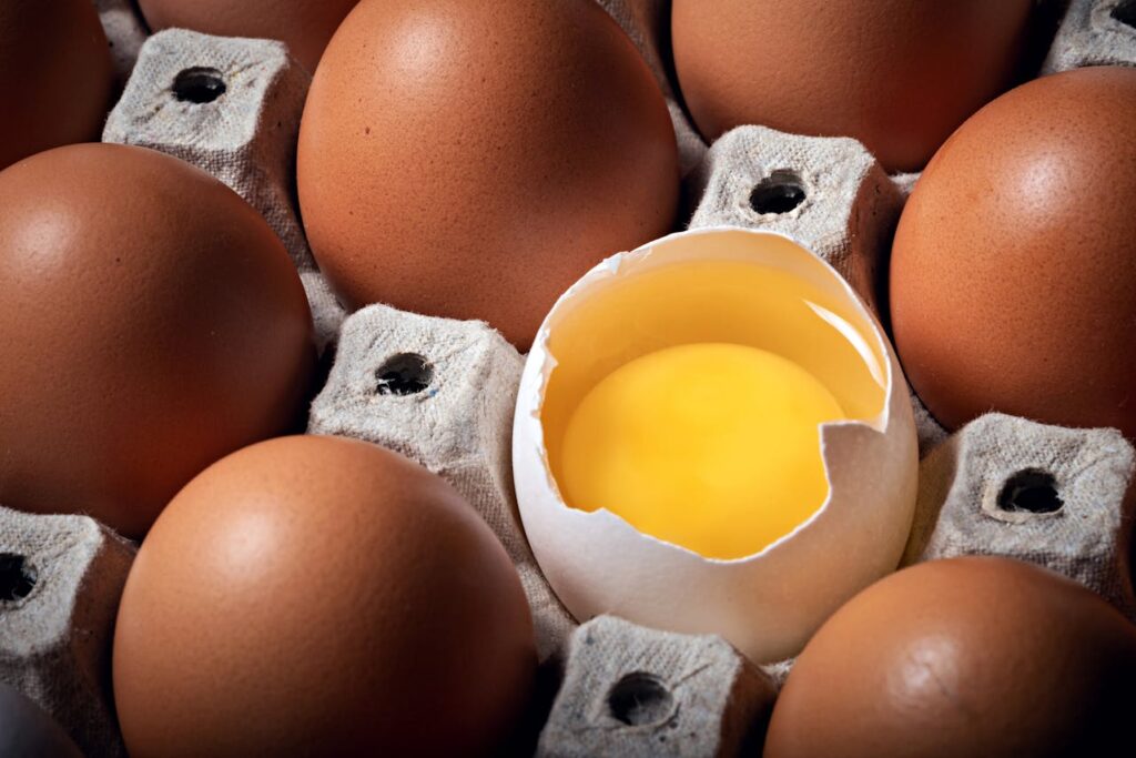 A carton of eggs with varying shell colors and visible texture.
