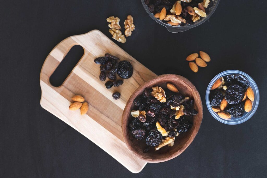 A small wooden bowl filled with raisins on a rustic table.