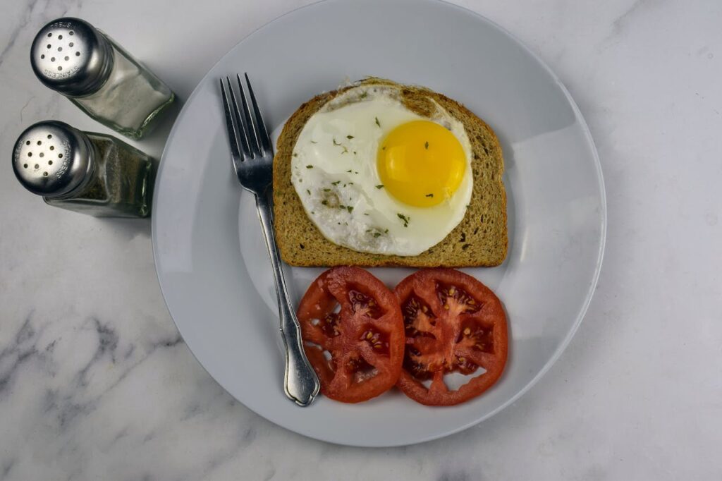 Pan-fried slices of scrapple with fried eggs on the side.