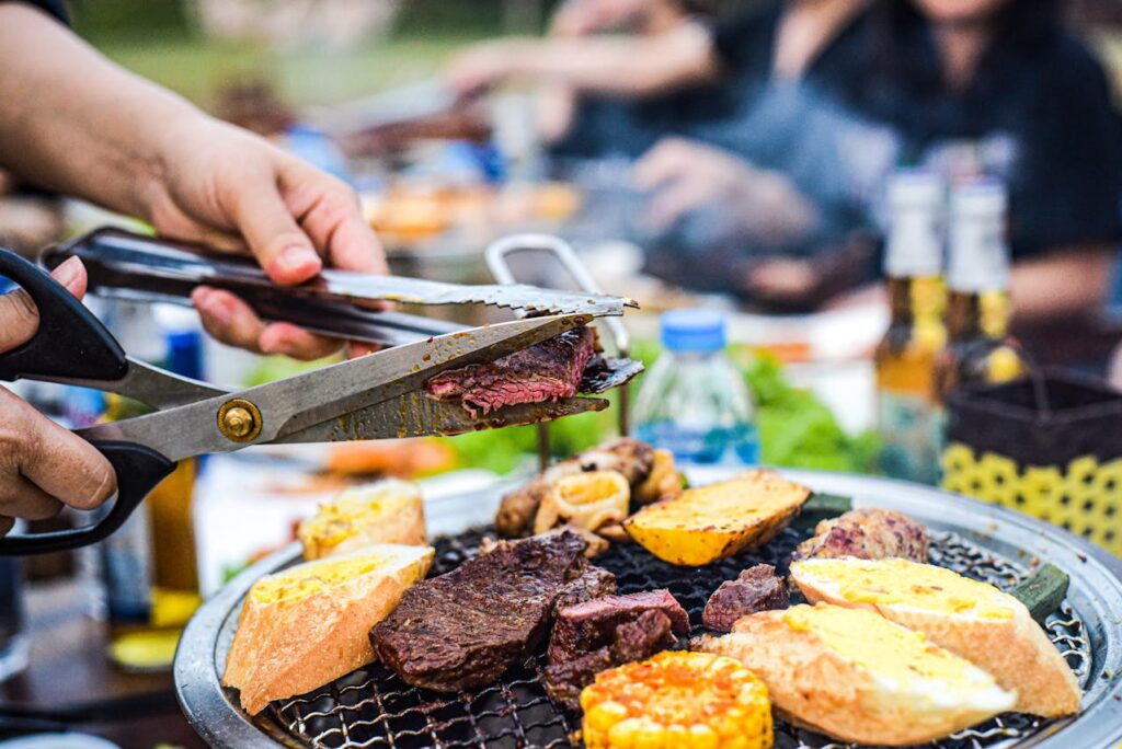 Backyard barbecue scene with brisket on the smoker and family gathered nearby.