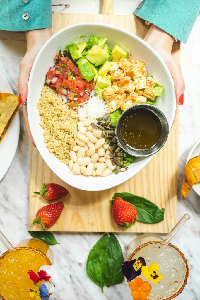A vibrant grain bowl with quinoa, roasted veggies, avocado, and dressing.