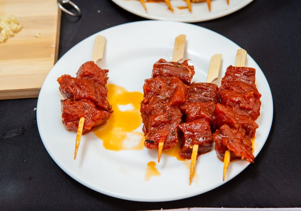 A plated serving of brisket slices with smoky bark, sides like coleslaw, and barbecue sauce.