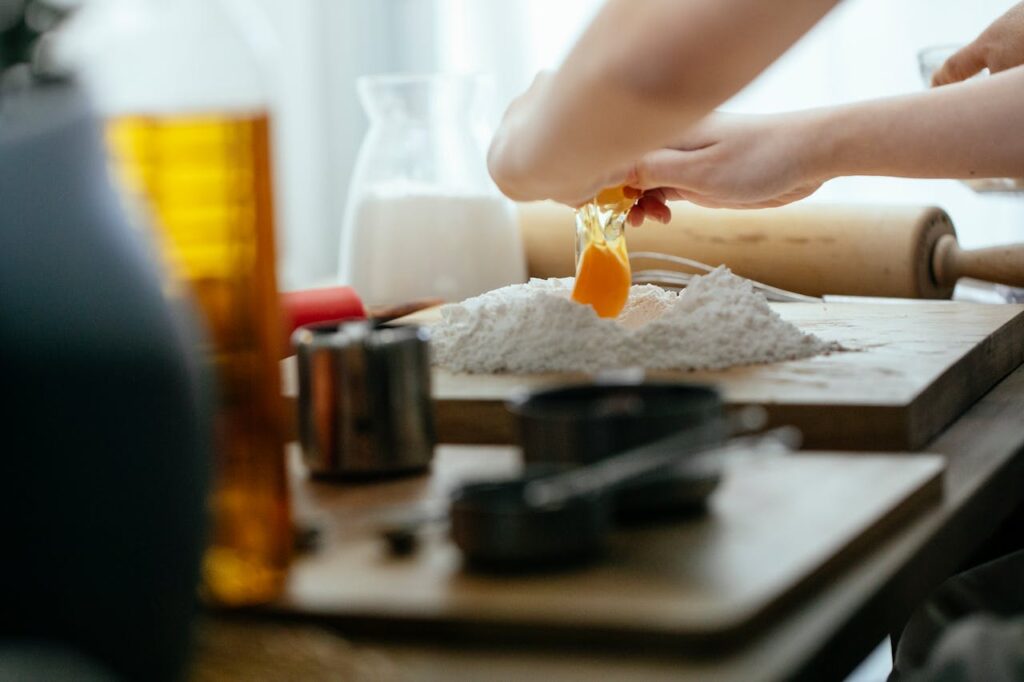 Crop cook adding egg to flour