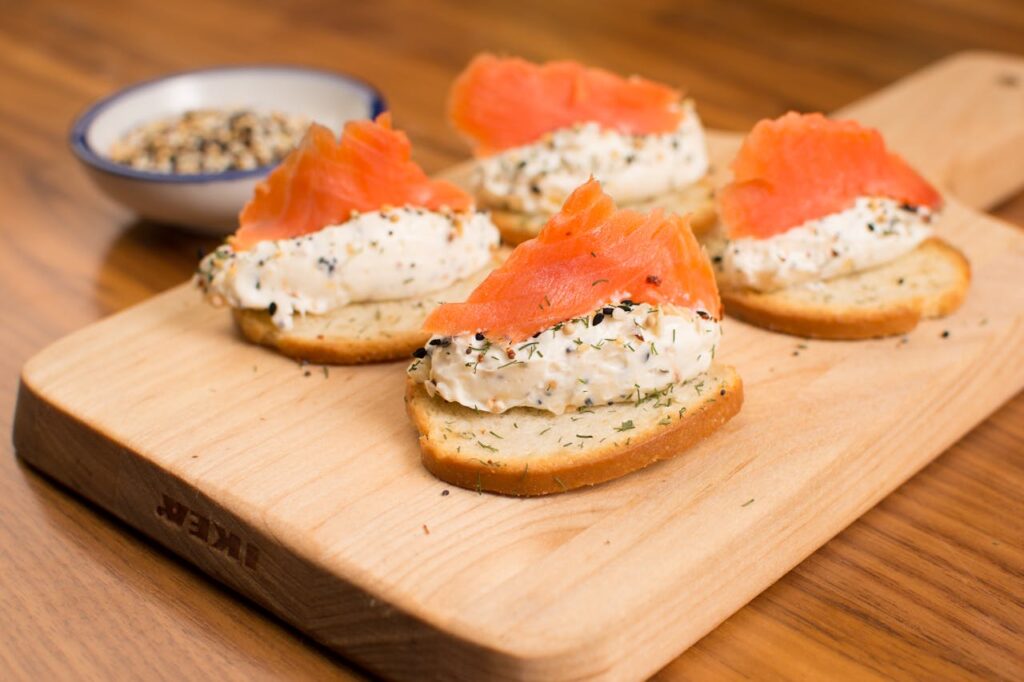 Bread with Smoked Salmon and Cottage Cheese on a Cutting Board