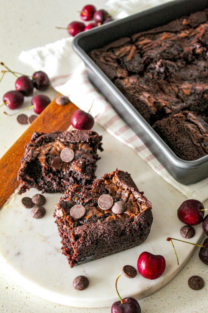 A thick pan of brownies cooling in an 8x8 baking dish.