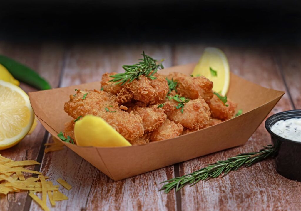 Crispy codfish cakes served with parsley and a lemon wedge.