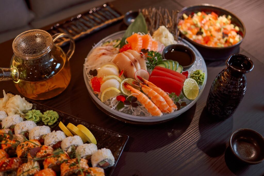 A sushi platter with rolls featuring avocado and tamago next to sashimi slices of tuna and salmon.