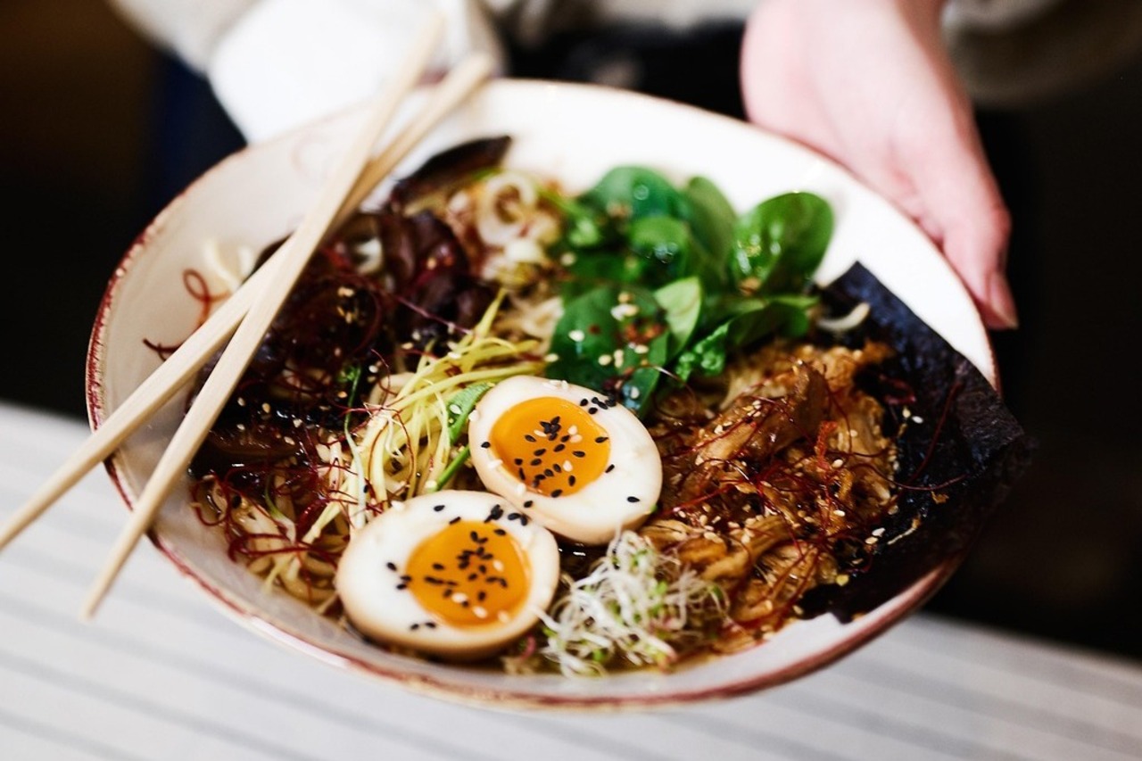Chicken ramen bowl with sliced egg and green onions.