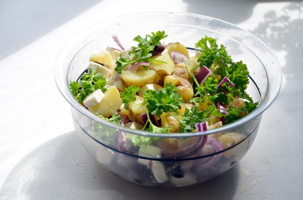 Potato salad garnished with paprika and parsley.