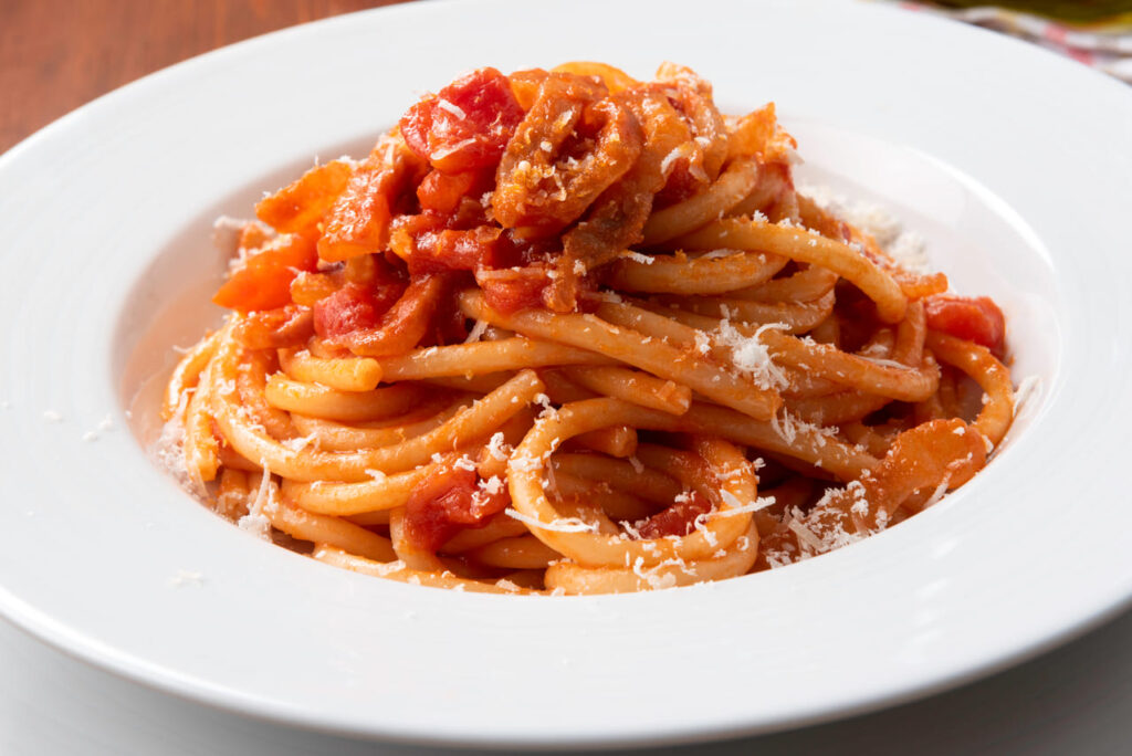 Bucatini all'amatriciana, traditional recipe of pasta with guanciale, pecorino and tomato sauce, Italian cuisine 