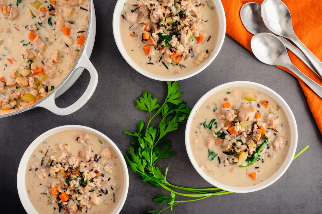 chicken and wild rice soup from a large pot, with steam rising.