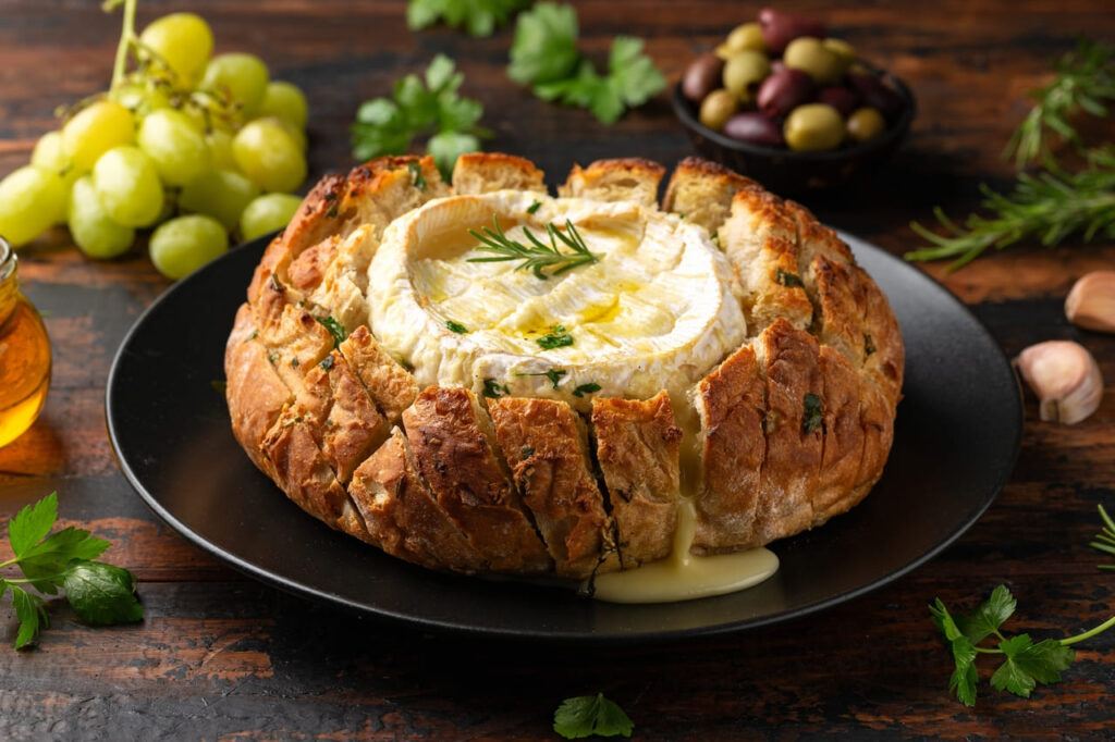 Baked Camembert cheese in sourdough bread with rosemary, garlic, thyme