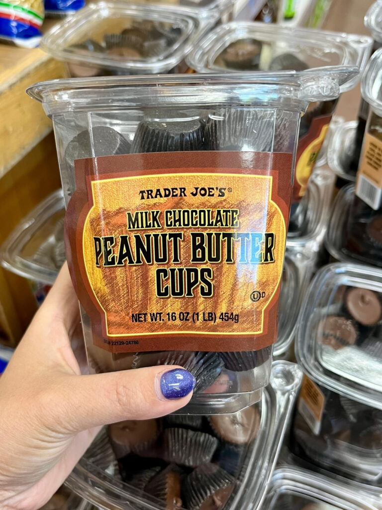 The top down view of a woman holding a package of Trader Joe's Milk Chocolate Peanut Butter Cups.