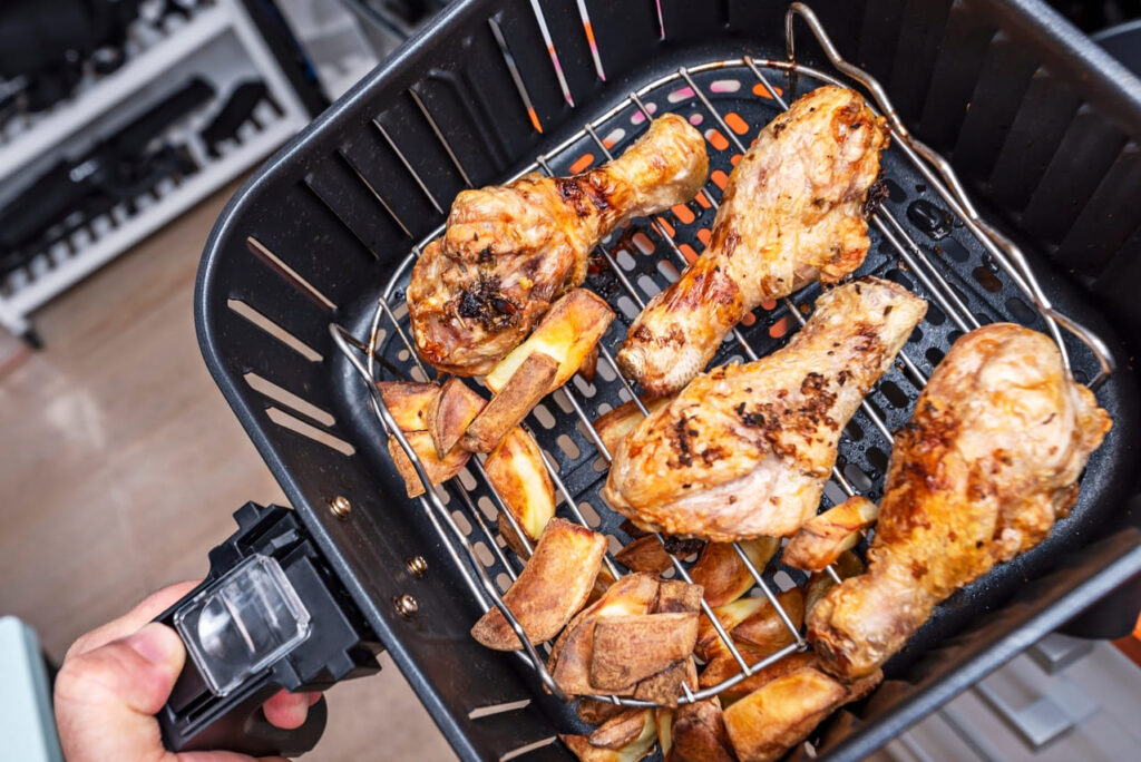 Chicken wings and roasted potatoes in air fryer.