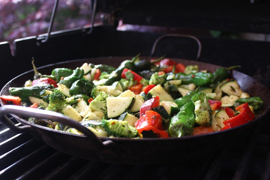A baking sheet of assorted roasted vegetables like carrots, zucchini, and Brussels sprouts.